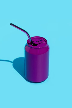 Purple soda can with straw on blue background