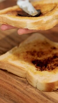 Spreading Vegemite on Toast in a Kitchen Setting