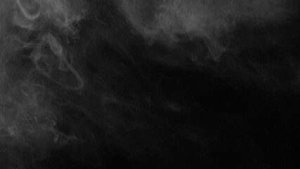 Static shot of dark, wispy fog provides a mysterious texture on a black background. Versatile moody overlay for cinematic projects - Powered by Adobe