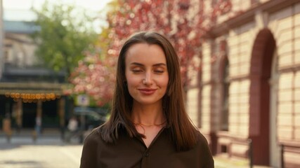 Portrait in city happy smiling Caucasian woman business girl female nod head yes answer positive answering businesswoman lady smile looking at camera posing at street outdoors agree gesture approve
