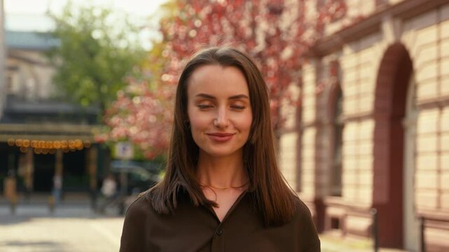 Portrait in city happy smiling Caucasian woman business girl female nod head yes answer positive answering businesswoman lady smile looking at camera posing at street outdoors agree gesture approve