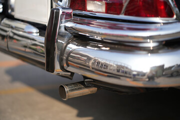 The chrome bumper of a vintage car glows with light, adding to the car classic allure and sleek...