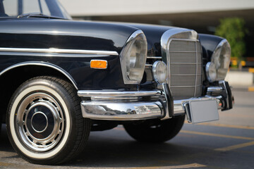 The chrome bumper of a vintage car glows with light, adding to the car classic allure and sleek...