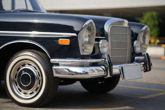 The chrome bumper of a vintage car glows with light, adding to the car classic allure and sleek design.