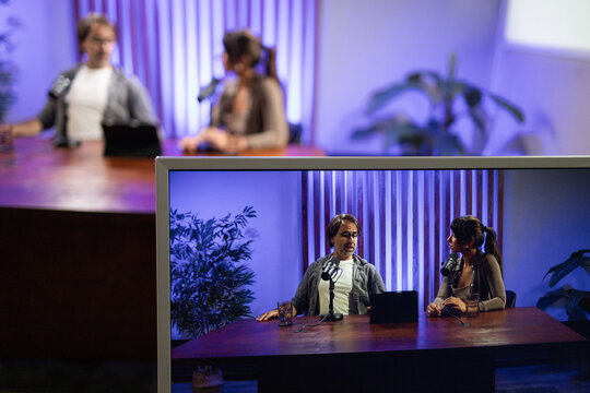 Man and woman recording a podcast in a studio setting