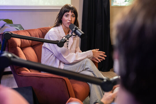 Woman and man recording a podcast in a studio