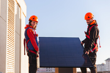 Rooftop solar panel installation with technicians at work