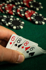 A player holds a strong poker hand showing two pairs, sixes and eights, while chips are scattered around the green felt table, creating an atmosphere of anticipation