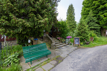 Green bench inviting visitors to the Lemko Museum in Sekowa, Poland