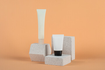 Plastic white tube for cream or lotion. Skin care or sunscreen cosmetic with stylish props on cream...