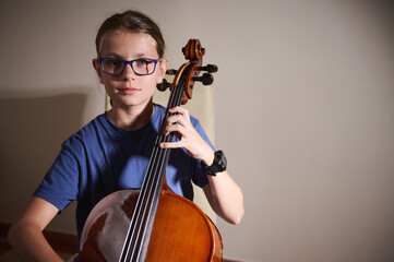 Young Musician Playing a Cello in a Dramatic Indoor Setting