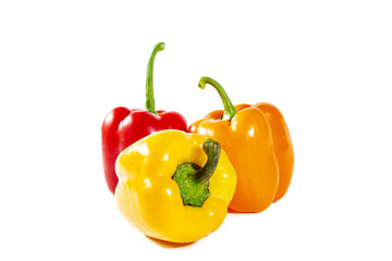 Fresh juicy shiny red, yellow and orange bell peppers. Isolated on white.