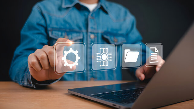 A person is using a laptop computer to access digital icons representing settings, technology, files, and documents for workflow management.