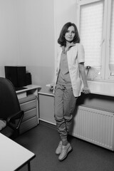 Beautiful Caucasian female doctor with short dark hair and white skin in a medical office