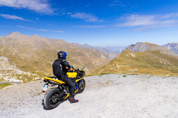 Motorcyclist admiring mountain landscape in Bonneval sur Arc, France