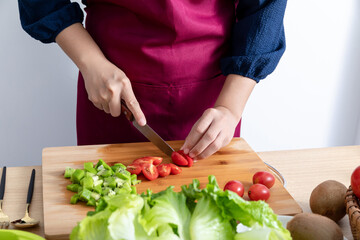 A young Chinese woman is making a vegetable salad