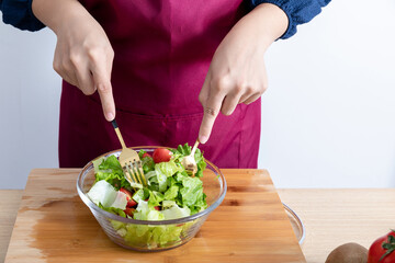 A young Chinese woman is making a vegetable salad