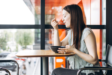 Woman enjoying cheesecake breakfast in a cozy cafe