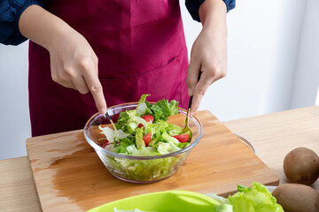 A young Chinese woman is making a vegetable salad