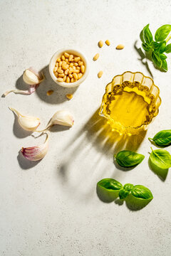 Pesto ingredients with olive oil on white background