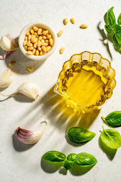 Top view of essential pesto ingredients on white background