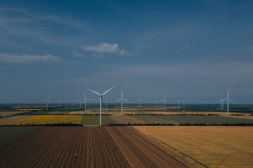 Aerial photography: Wind turbines producing clean energy. Wind farm. Top view of agricultural...