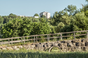 Brückenauffahrt Blaue Brücke aus Natursteinen mit halbrundem Bogen und Geländer aus Holz vor...
