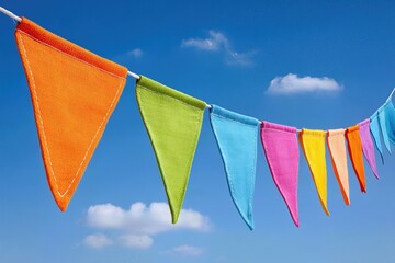 Colorful fabric bunting against a bright blue sky with soft white clouds