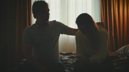 couple in love sitting on bed dark bedroom, family problem. upset sad woman nervous stressed worries suffers. Man supports crying woman, guy hugging girl with hand calms down. Depression mental health