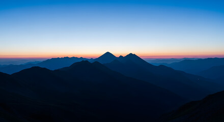 Layers of mountain silhouettes create a beautiful gradient at twilight