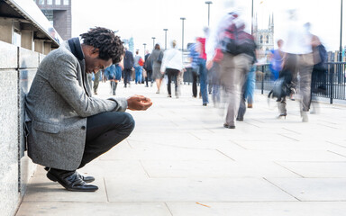 Down and Out. A character begging for charity on the busy streets of London. 