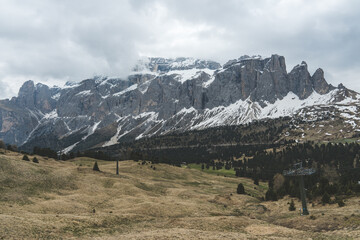 Mountain range of Sella Group with snow and cloudy sky in Dolomites, Italy.