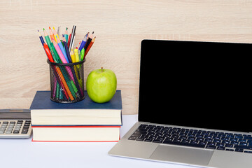 A Modern Study Workspace Featuring a Laptop, Various Books, and Creative Supply Items