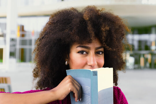 Woman reading a book with curiosity outdoors