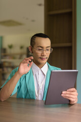 portrait of a young non binary gay man doctor with tablet computer
