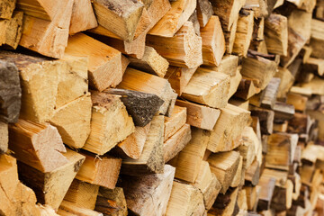 Close-up view of stacked firewood logs, showcasing natural wood texture and warm tones, prepared...