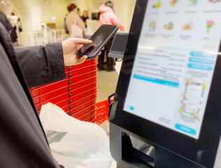 Self-checkouts or self-service checkouts,man paying for the purchases  in supermarkets