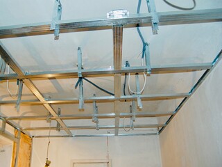 Installing ceiling metal frame with U-shaped brackets and mineral wool insulation for drywall -...