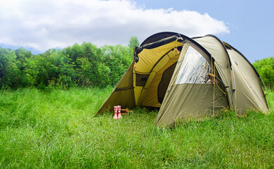 Tourist tent on a green meadow. Set up tourist tent in a camping site in nature in the forest....