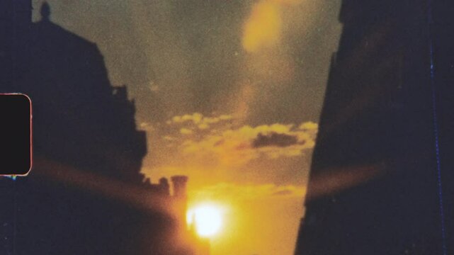 Super 8 film look sunset over city buildings