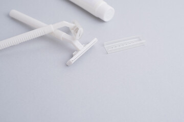 Disposable plastic razor with steel blade, men's and women's razors and shaving cream. Skin and body care concept. Depilation. Space for text
