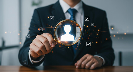 Human Resources Focus: A businessperson employs a magnifying glass to highlight a human silhouette, suggesting recruitment, assessment, and the importance of personnel evaluation in business strategy.