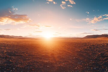 Stunning view of a sunset over a vast desert plain with distant mountain range and dramatic cloud formations.