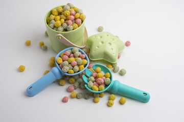 Children's toys, a shovel, a rake and crispy colorful snacks. Summer mood on the beach