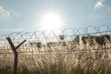 Barbed wire fence under a bright sun