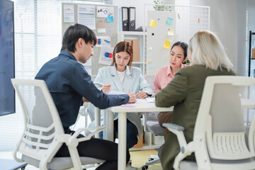 diverse business professionals engage in a dynamic brainstorming meeting, analyzing AI-powered...