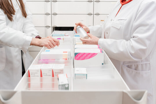 Close up of Two pharmacists checking medicine inside a drawer in pharmacy