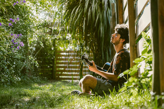 Man playing guitar in La Paloma garden setting