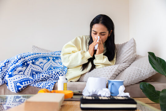 Woman battling illness at home wrapped in blanket