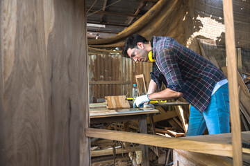 Fototapeta premium Carpenter man searching on laptop working in carpentry workshop
